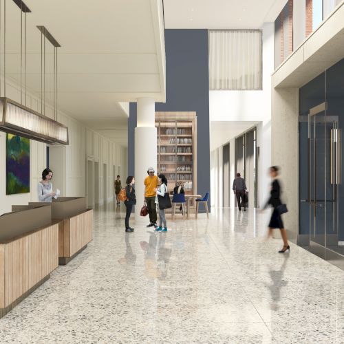 A modern lobby with people interacting by a reception desk, featuring sleek design elements, art, and large windows for natural light.